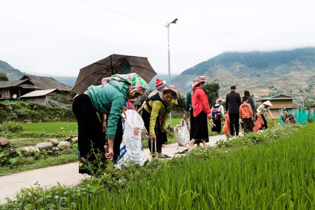 Join locals to pick up trash to clean village